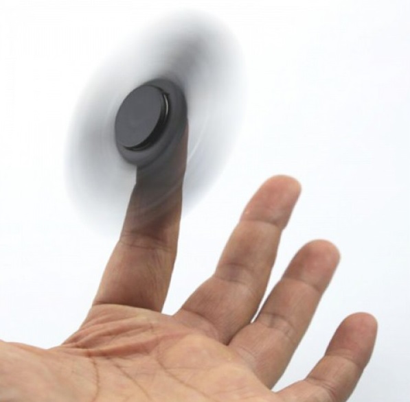 Uchopte Fidget spinner v jeho středu mezi palec a ukazováček. Druhou rukou ho roztočte.